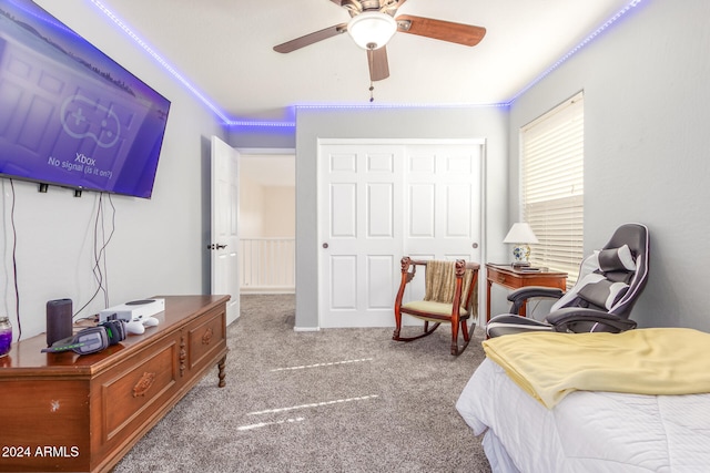 carpeted bedroom featuring ornamental molding, a closet, and ceiling fan