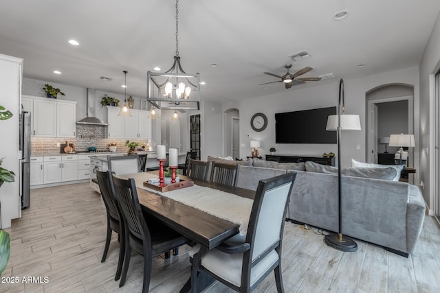 dining room featuring ceiling fan with notable chandelier