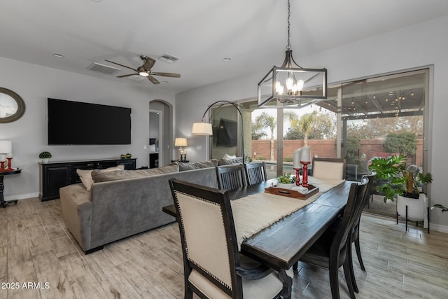 dining room with ceiling fan with notable chandelier