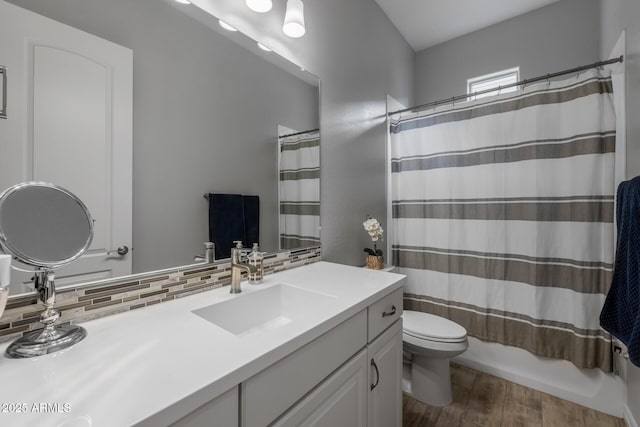 full bathroom with hardwood / wood-style floors, toilet, decorative backsplash, vanity, and shower / tub combo