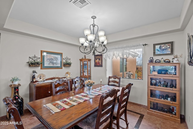 dining area featuring visible vents, a raised ceiling, tile patterned flooring, baseboards, and a chandelier