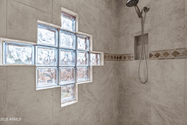 interior details featuring tiled shower