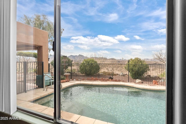 view of swimming pool with fence and a mountain view