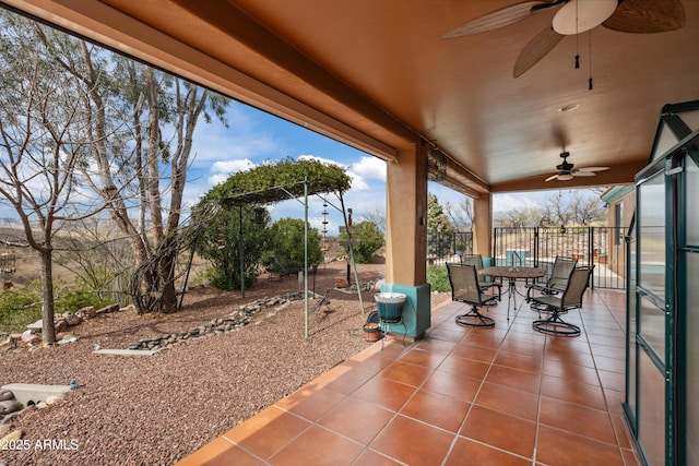 view of patio / terrace with outdoor dining area, ceiling fan, and fence