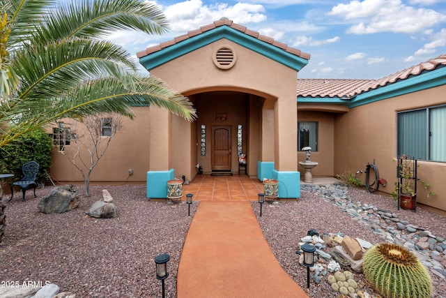 property entrance featuring stucco siding and a tiled roof