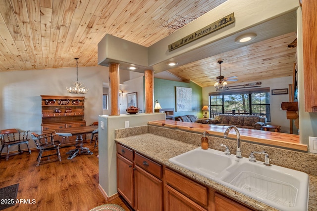 kitchen featuring hanging light fixtures, sink, wooden ceiling, and light hardwood / wood-style floors