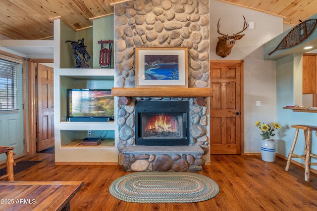 living room featuring wood ceiling, vaulted ceiling, a stone fireplace, and hardwood / wood-style flooring