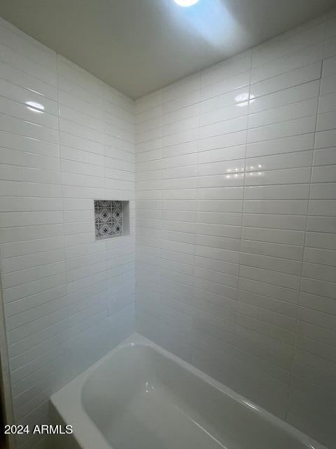 bathroom featuring tiled shower / bath