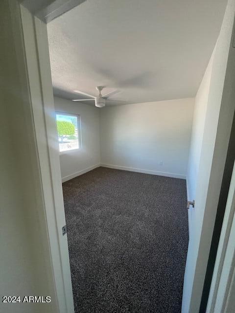 carpeted empty room featuring ceiling fan