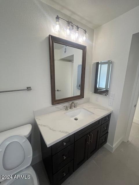 bathroom featuring tile patterned floors, vanity, and toilet