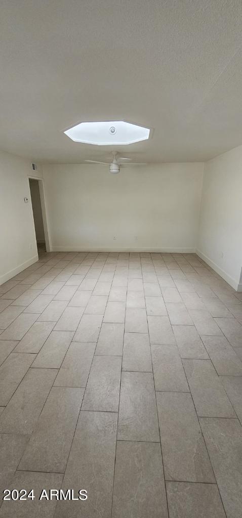 tiled empty room featuring a textured ceiling