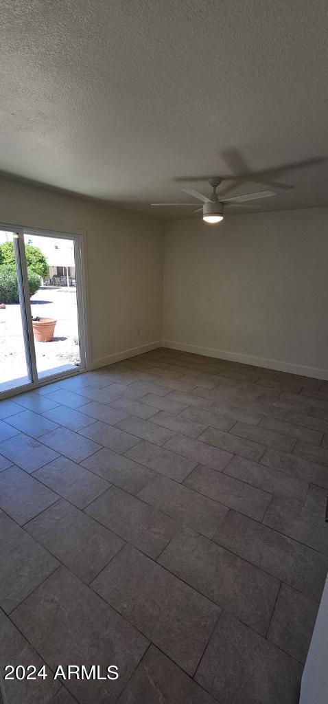 spare room with ceiling fan and a textured ceiling