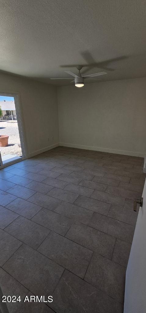 spare room featuring ceiling fan and a textured ceiling