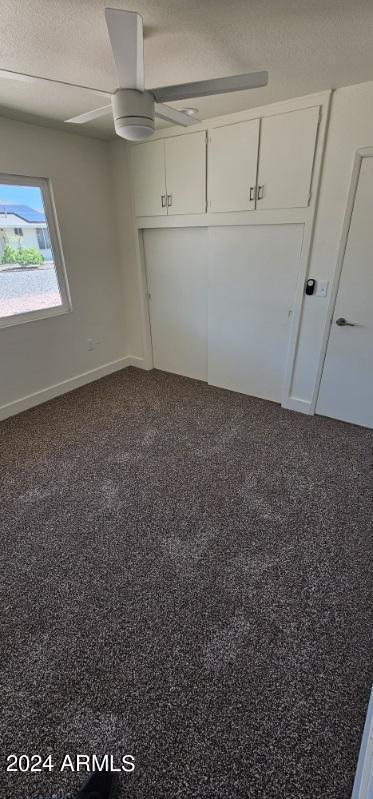 unfurnished bedroom featuring ceiling fan, a closet, and carpet