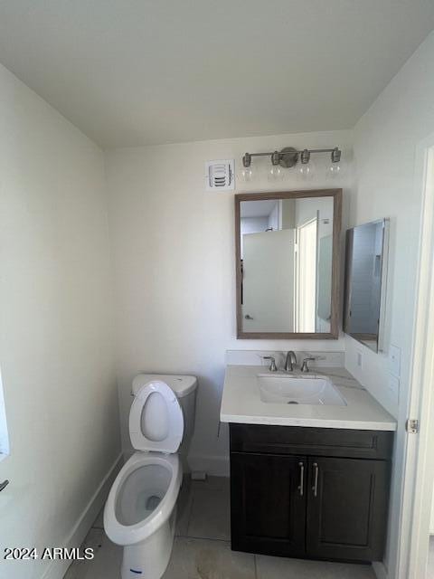 bathroom with tile patterned flooring, vanity, and toilet