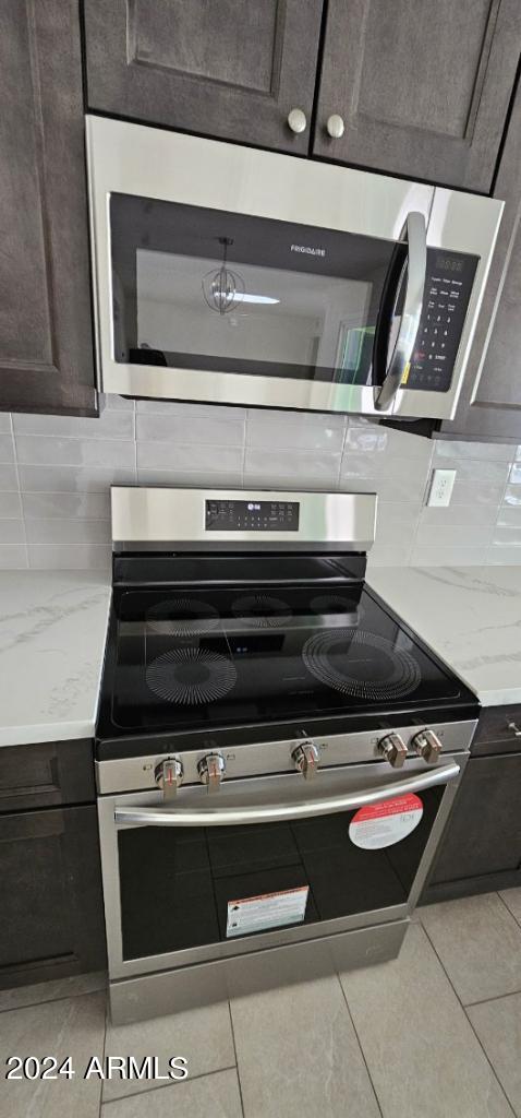 interior details with dark brown cabinets, stainless steel appliances, and decorative backsplash