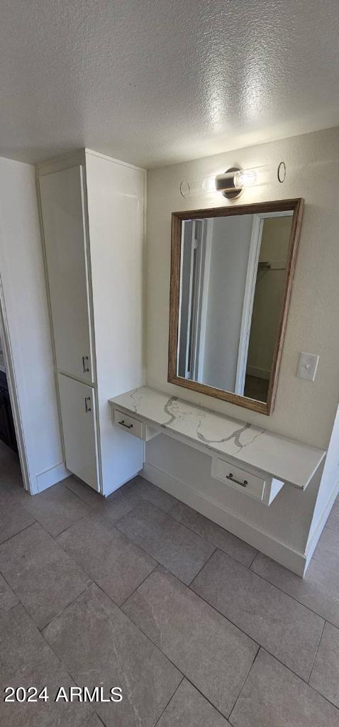 bathroom with tile patterned floors and a textured ceiling