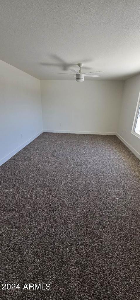 unfurnished room featuring carpet floors, a textured ceiling, and ceiling fan