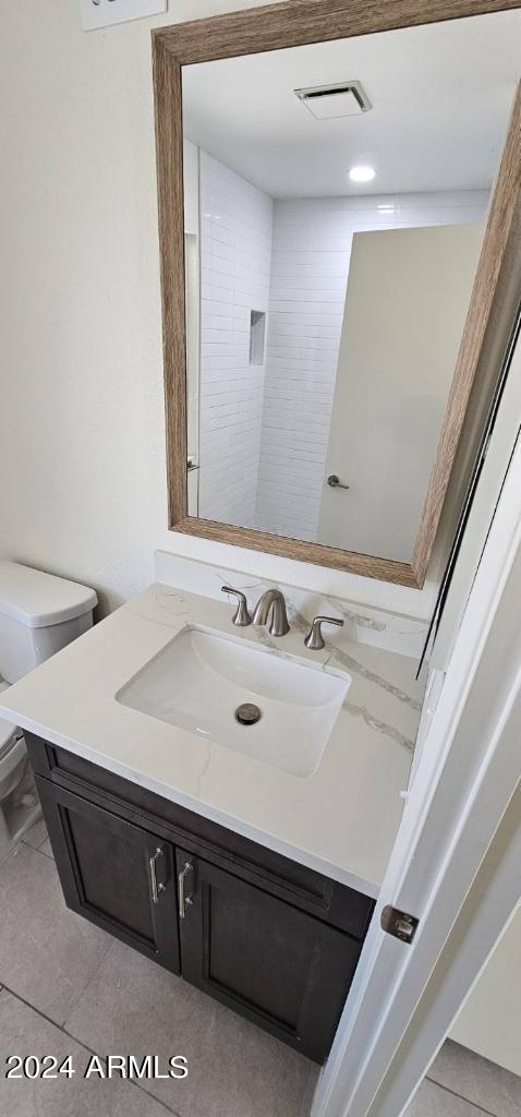 bathroom featuring tile patterned floors, vanity, and toilet