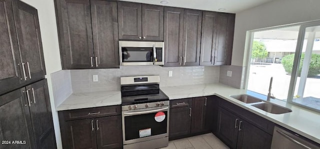 kitchen with decorative backsplash, appliances with stainless steel finishes, sink, and dark brown cabinets