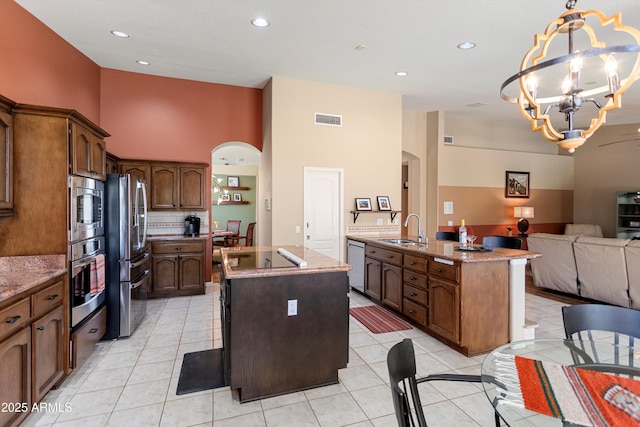 3797 N 156th Dr N, Goodyear, AZ 85395 - kitchen featuring visible vents, arched walkways, appliances with stainless steel finishes, and a center island with sink