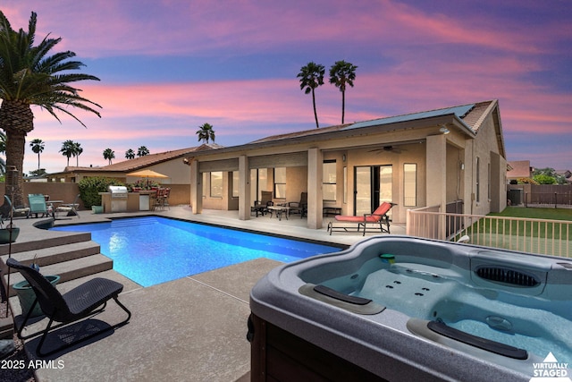 3797 N 156th Dr N, Goodyear, AZ 85395 - pool at dusk with a hot tub, ceiling fan, a fenced backyard, a fenced in pool, and a patio