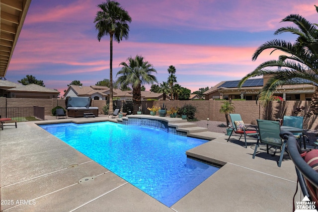 3797 N 156th Dr N, Goodyear, AZ 85395 - pool at dusk with a patio, a fenced backyard, a hot tub, and a fenced in pool