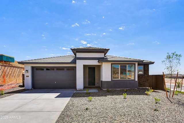 5875 N 193rd Dr, Litchfield Park, AZ 85340 - prairie-style house featuring stucco siding, fence, concrete driveway, a garage, and a tiled roof