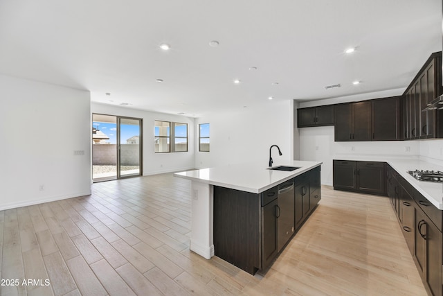 5875 N 193rd Dr, Litchfield Park, AZ 85340 - kitchen with a sink, open floor plan, light wood-style floors, light countertops, and stainless steel gas cooktop