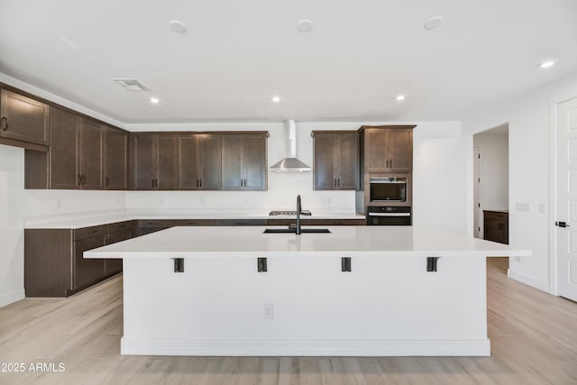 5875 N 193rd Dr, Litchfield Park, AZ 85340 - kitchen featuring visible vents, a sink, wall oven, black microwave, and wall chimney exhaust hood