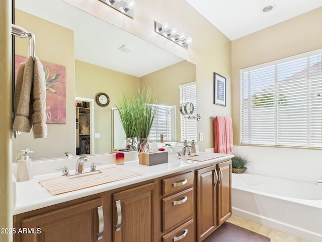 full bathroom with a sink, a bath, double vanity, and tile patterned flooring