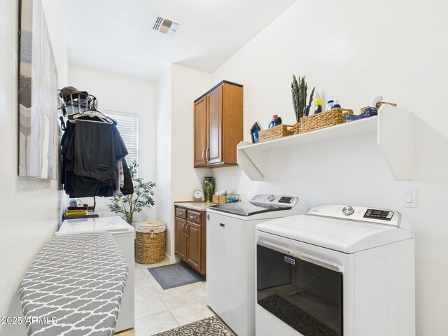 laundry area with washer and dryer, light tile patterned floors, cabinet space, and visible vents