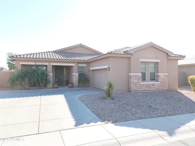 view of front of home with stone siding, stucco siding, and an attached garage