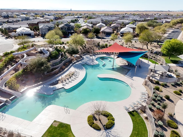 view of swimming pool with a residential view, a community hot tub, and a water slide