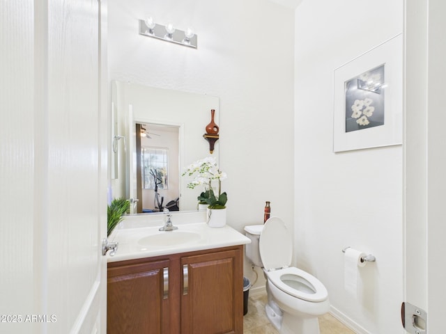 half bath featuring vanity, tile patterned floors, and toilet