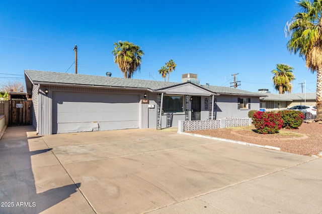 single story home featuring a garage, driveway, a shingled roof, and fence