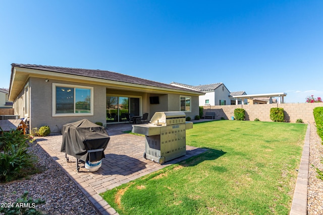 back of house with a patio and a yard