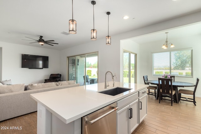 kitchen with a wealth of natural light, a kitchen island with sink, sink, and stainless steel dishwasher