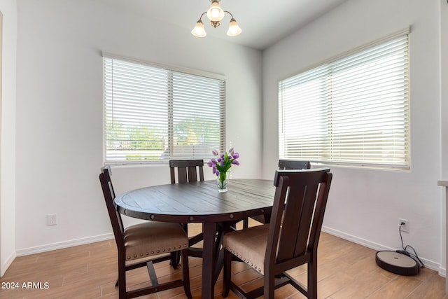 dining area featuring a notable chandelier, light hardwood / wood-style floors, and a healthy amount of sunlight