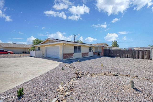 ranch-style home featuring concrete driveway, brick siding, an attached garage, and fence