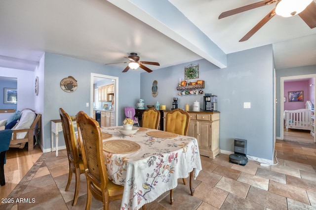 dining area featuring baseboards, ceiling fan, and stone finish flooring