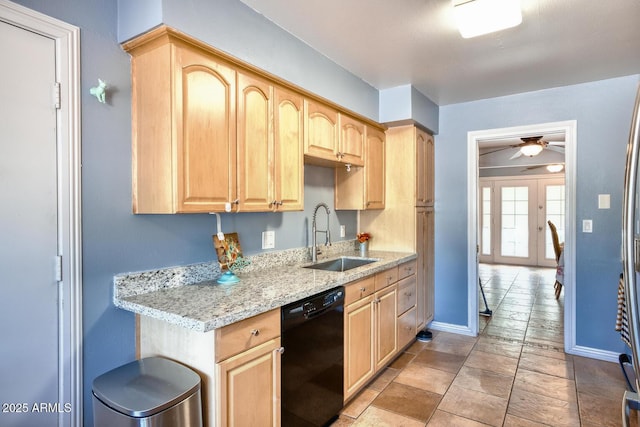 kitchen featuring light brown cabinetry, light stone countertops, baseboards, a sink, and dishwasher