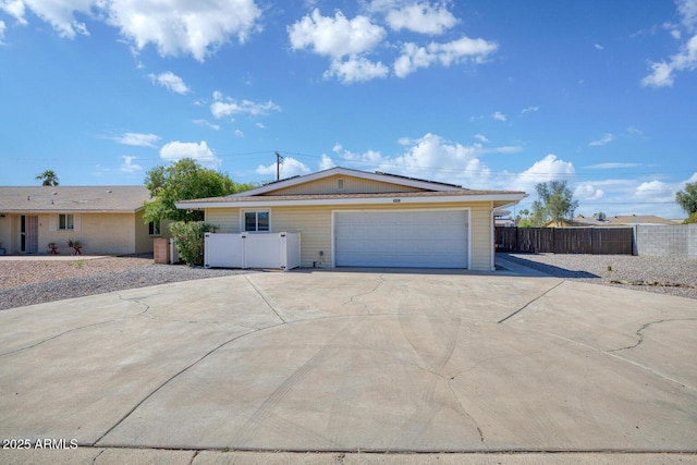 ranch-style house with fence, driveway, and solar panels
