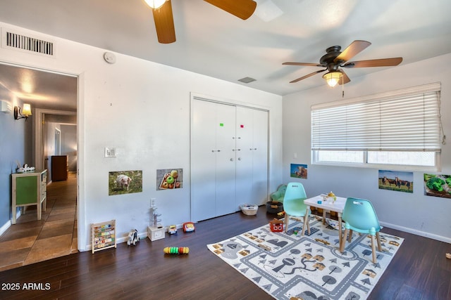 game room featuring visible vents, a ceiling fan, baseboards, and wood finished floors