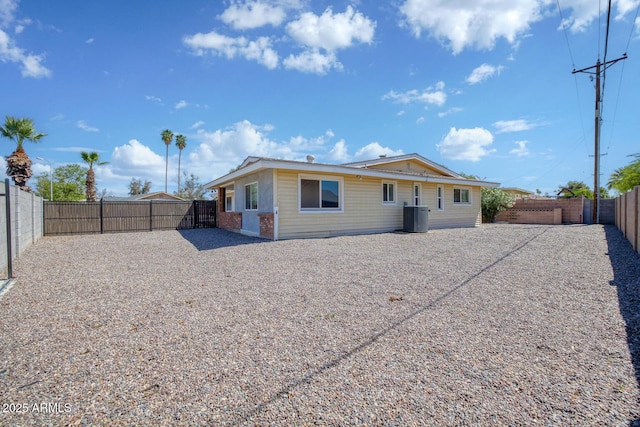 rear view of property featuring central AC unit and a fenced backyard