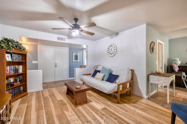 living area with a ceiling fan, visible vents, and light wood finished floors