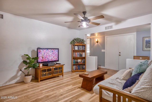 living area with a ceiling fan, baseboards, visible vents, and light wood-type flooring
