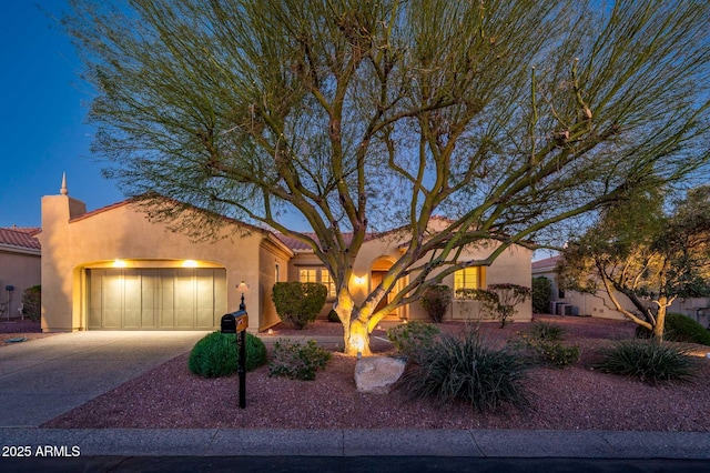 view of front of property featuring a garage, concrete driveway, a tiled roof, and stucco siding