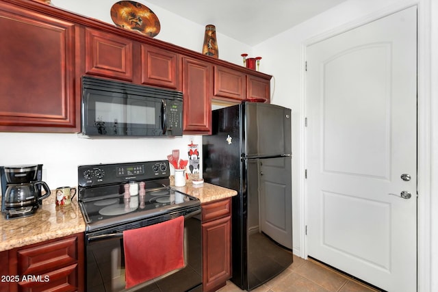 kitchen featuring light stone counters, reddish brown cabinets, black appliances, and tile patterned flooring