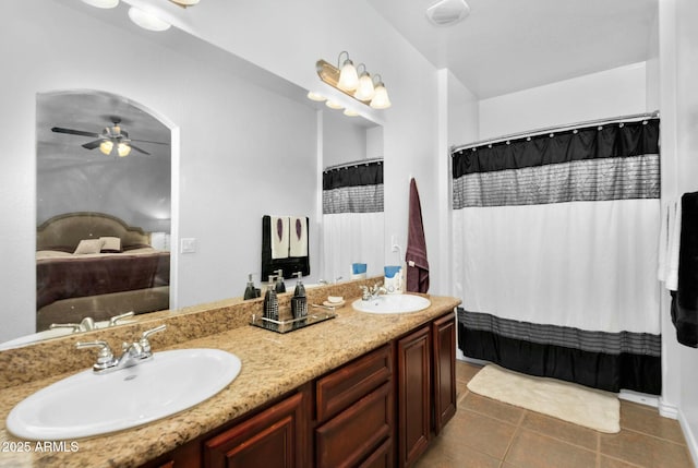 ensuite bathroom featuring tile patterned flooring, connected bathroom, a ceiling fan, and a sink